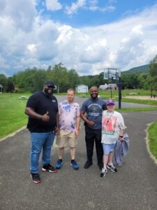 Tevin and Schnyder pose with campers at Camp Loyaltown