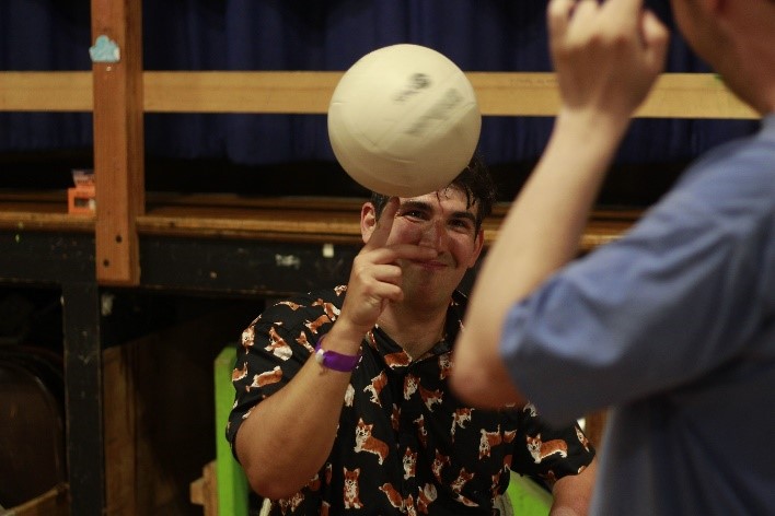 A camper plays volleyball indoors.