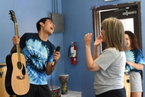Two campers do karaoke together