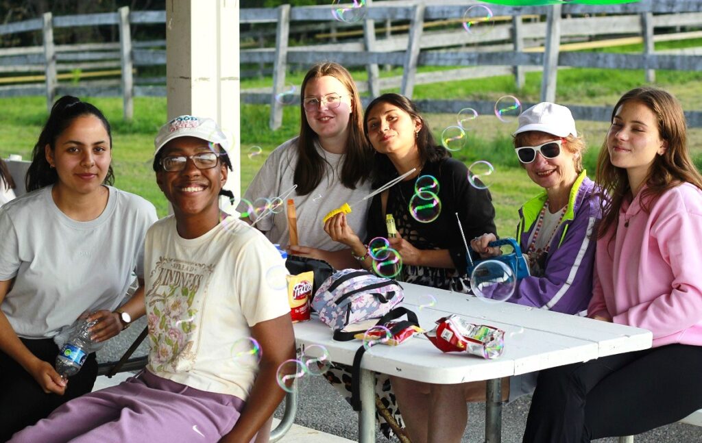 Campers and staff blow bubbles outside together