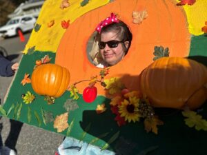 A Helen Kaplan Center resident poses for a pumpkin-themed photo.