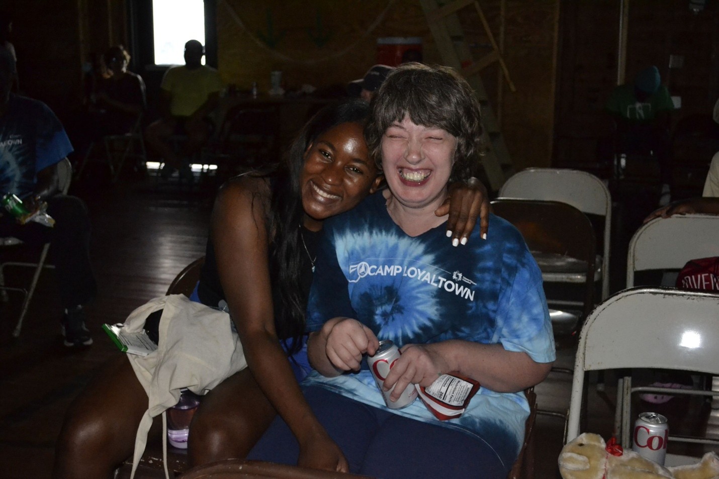 A Camp Loyaltown counselor with her arms around a camper.