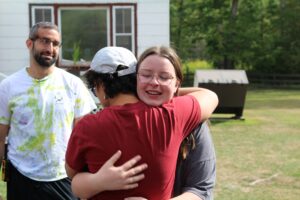 A Camp Loyaltown camper hugs a counselor goodbye.