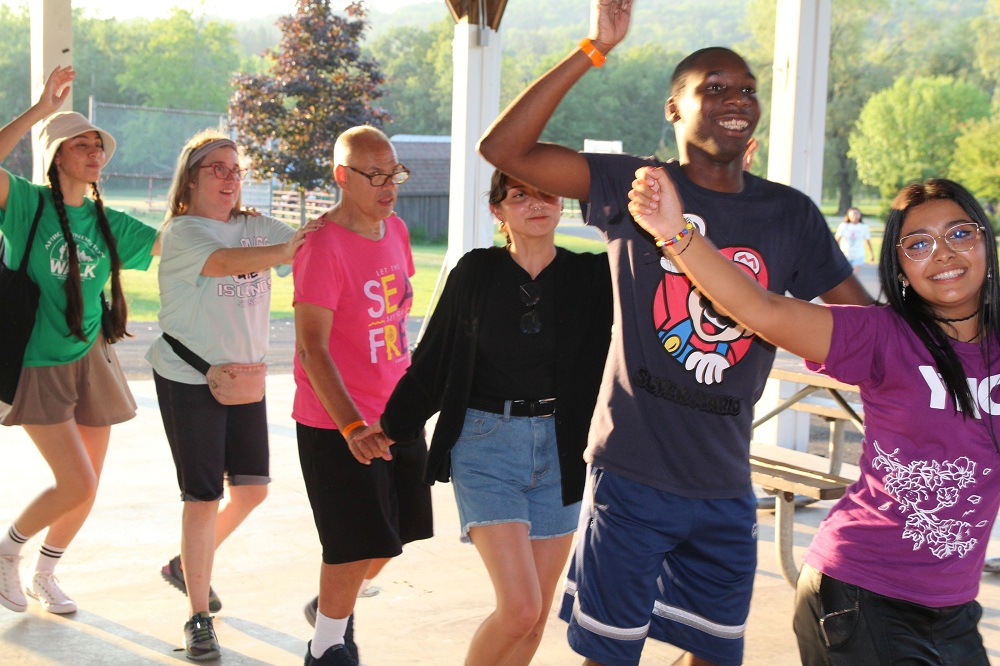 Camp Loyaltown staff and campers dance in a line