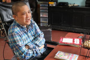 A person supported by Citizens sits at a table.