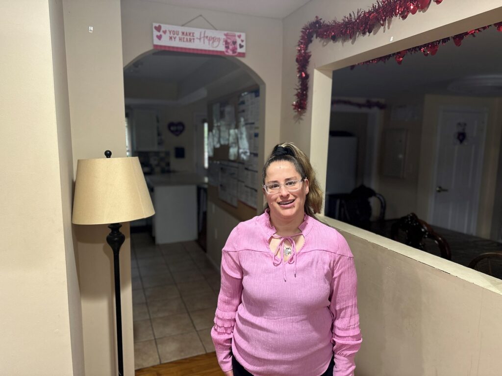 A person supported by Citizens poses in her home.