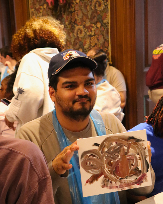 Citizens Sip and Paint 21 | Citizens Options Unlimited A person supported by Citizens holds up his painting at the Paint & Sip event.