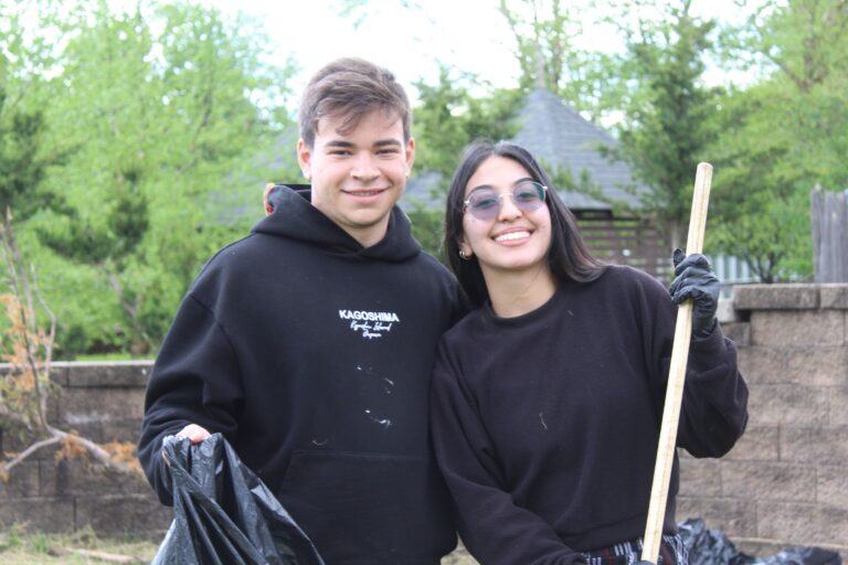 Two Camp Loyaltown counselors with a shovel anda garbage bag for cleaning up the camp.