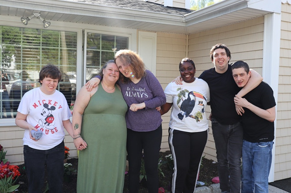 Citizens-May-Newsletter-PW-Blvd-Garden | Citizens Options Unlimited Six people standing arm-in-arm outside a beige house, smiling at the camera. (group photo)