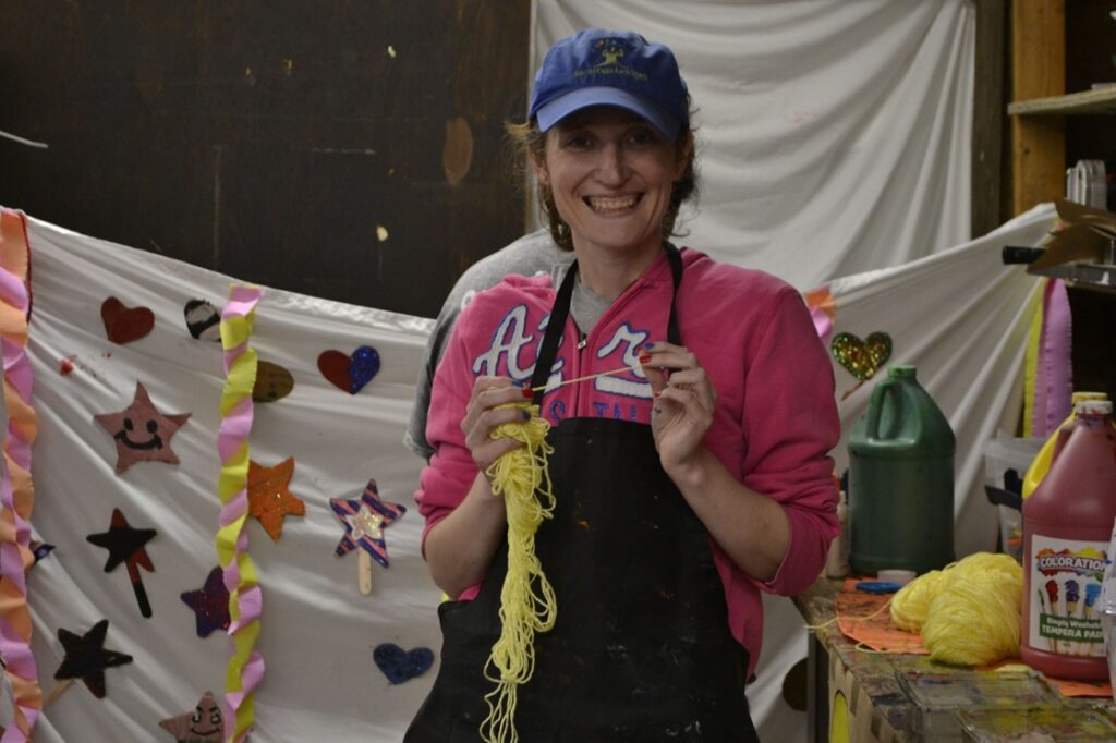_DSC0005 | Citizens Options Unlimited Camp Loyaltown camper Emily Brown holds up yellow string as she works in Craft Corner