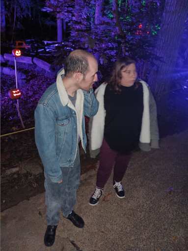 Two people look at jack o'lanterns