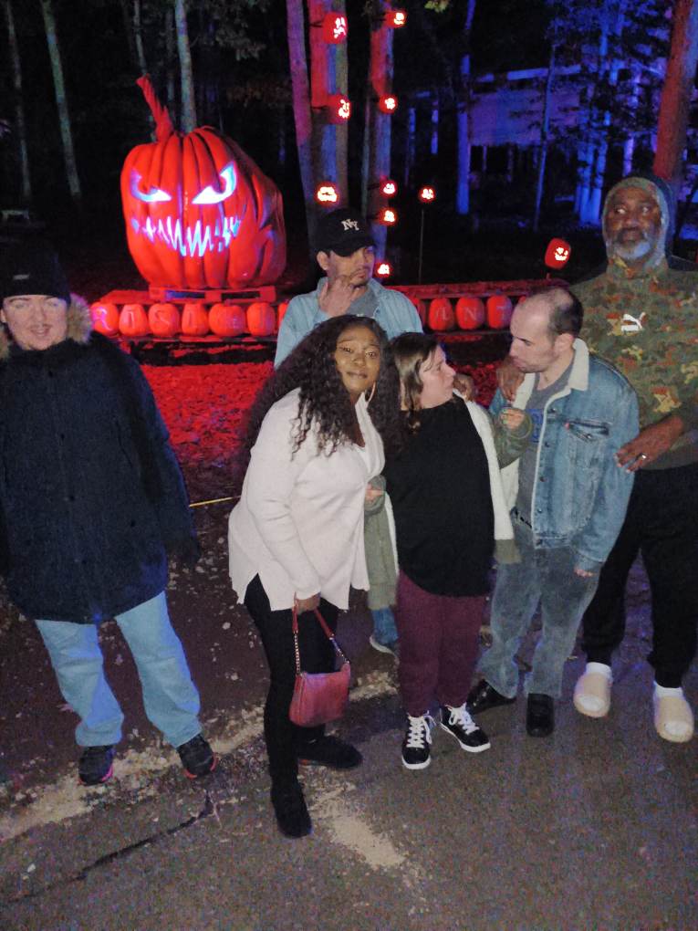group poses in front of jack o'lantern