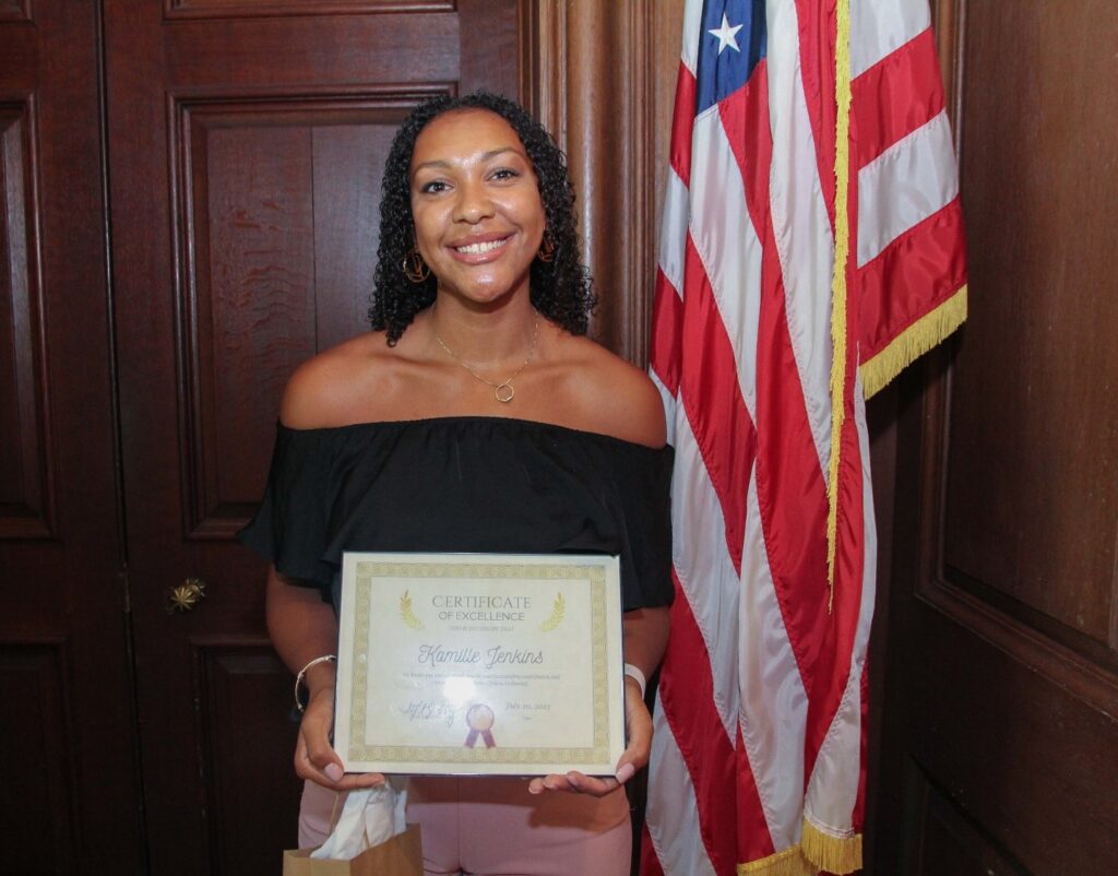 Kamille Jenkins poses with her Employee of the Quarter certificate