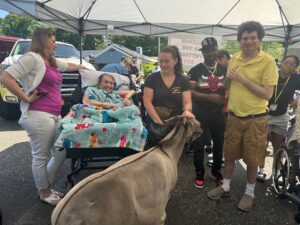 Helen Kaplan Center residents petting and feeding farm animals from Long Island Pony Parties and Petting Zoo.