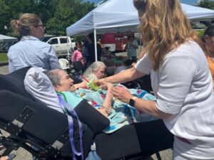 Guardianship Manager Eileen Stewart-Rooney handing Roz Adler, a resident, a lemon-lime snow cone.