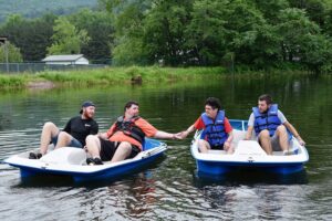 Campers and staff enjoy riding pedal boats at Camp Loyaltown