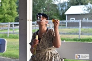 A Camp Loyaltown camper blows bubbles.