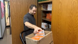 Peter Hadfield stocking the shelves in the Plainview office
