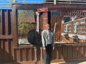 Randy stands next to the ostrich sign.