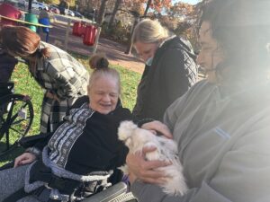 A resident of the Shoreham Intermediate Care Facility pets a chicken from the petting zoo
