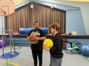 Two people supported by Citizens playing basketball at weekend respite.