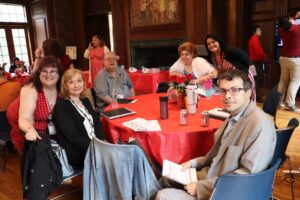 Matt Hofele and others gathered around a table at the Personal Outcome Measures (POMs) Rally.