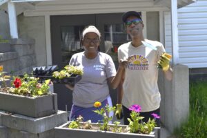 Two Camp Loyaltown staff members getting ready for opening day by planting flowers.