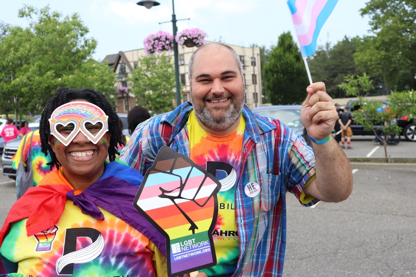 Attendees at the PrideAbility Pride Parade pose for a photo with their sign and flag.
