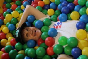 A camper enjoys the ball pit at Camp Loyaltown