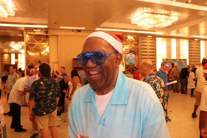 A Citizens residents dresses up in sunglasses and a Santa hat at the Holly Jolly party.