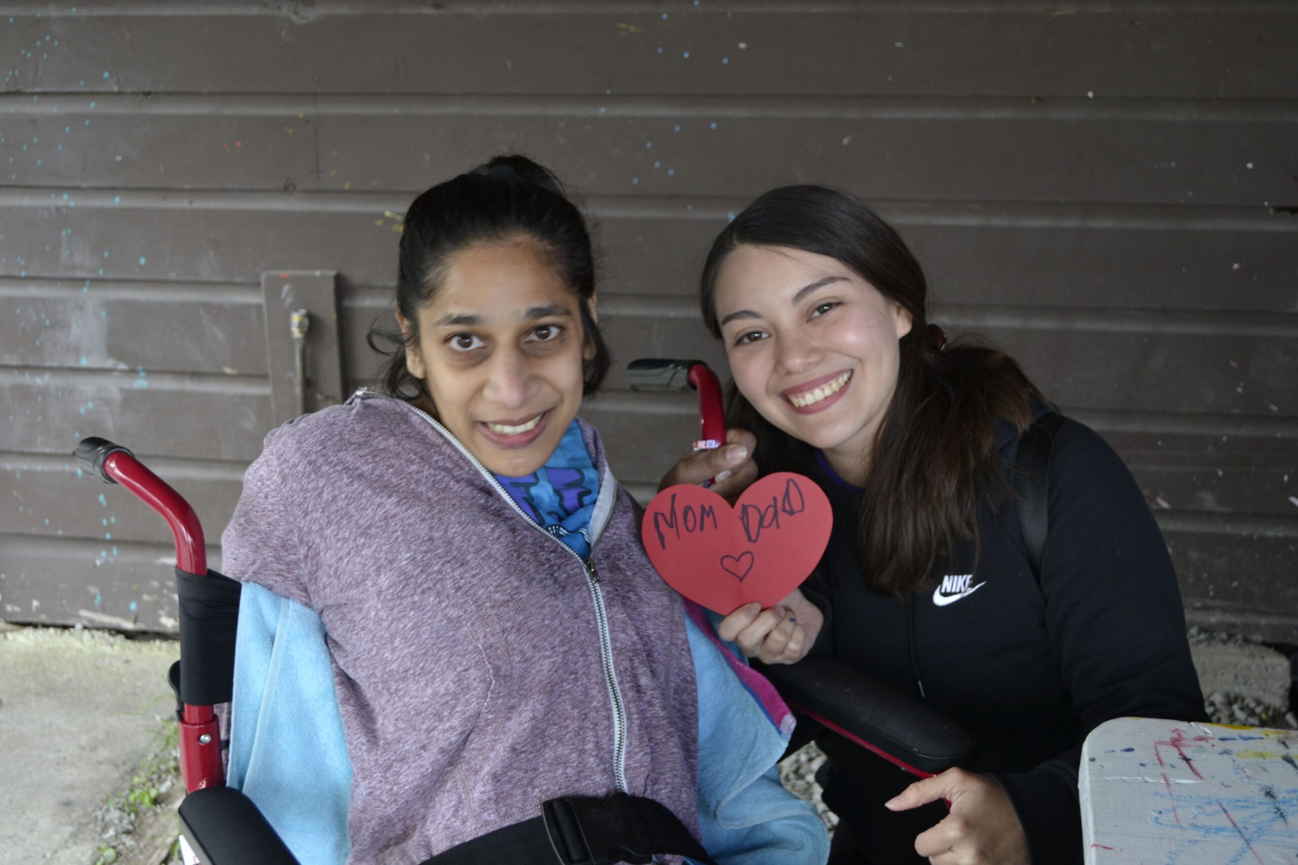 A Camp Lotyaltown camper shows of her craft with a staff member.