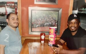 Nicholas and his DSP, Melbourne Henry sit at a table at a restaurant