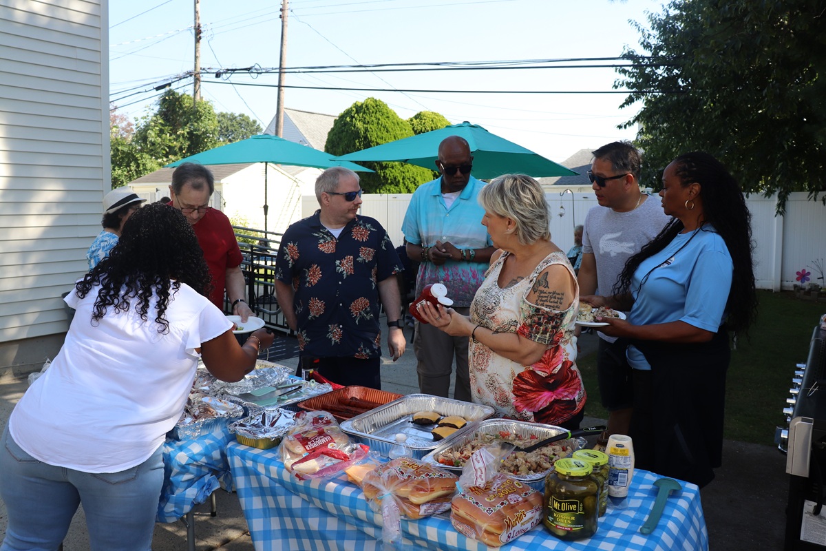 Residents and staff members at Ontario Avenue get food at their annual summer barbecue.