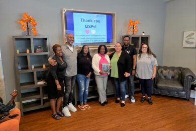 People supported at Red Spring Lane hold up a plaque given to them by Glen Cove nonprofit i Am My Sister for their active participation in the Hope N’ Motion Walk for Youth Mental Health Awareness.