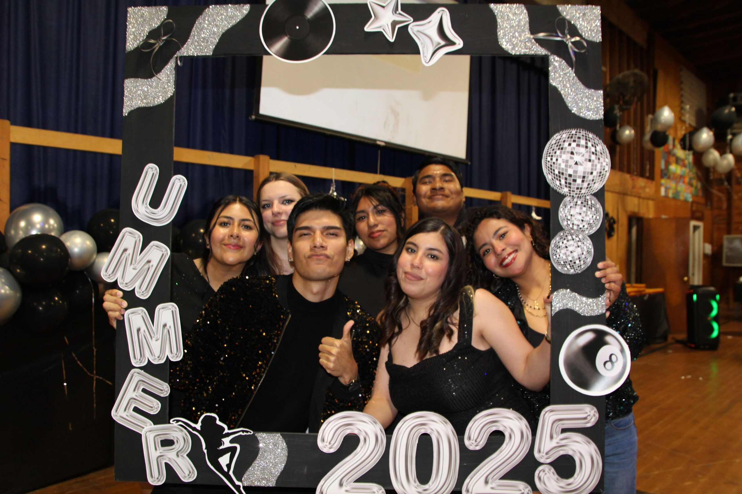 Six Camp Loyaltown staff members pose for a photo inside a frame at Staff Appreciation Night