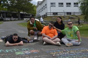 Camp Loyaltown campers draw with chalk on the pavement.