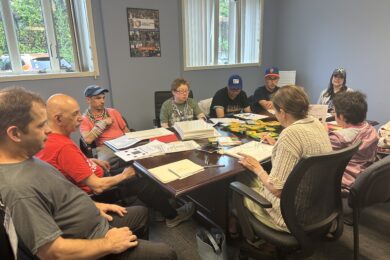 Jamie Allen sits at a table with others as she prepares for her Personal Outcome Measures presentation.