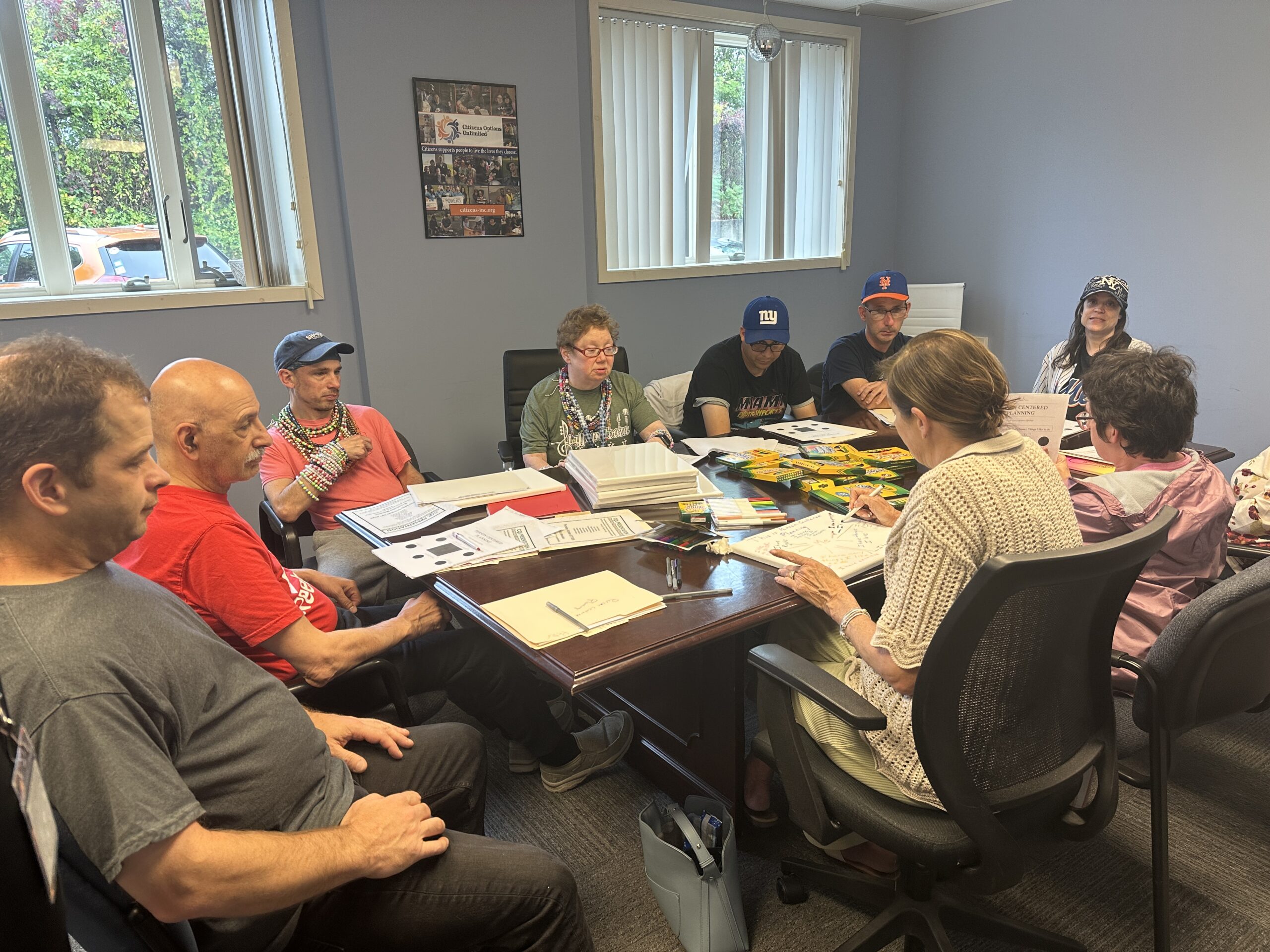 Jamie Allen sits at a table with others as she prepares for her Personal Outcome Measures presentation.