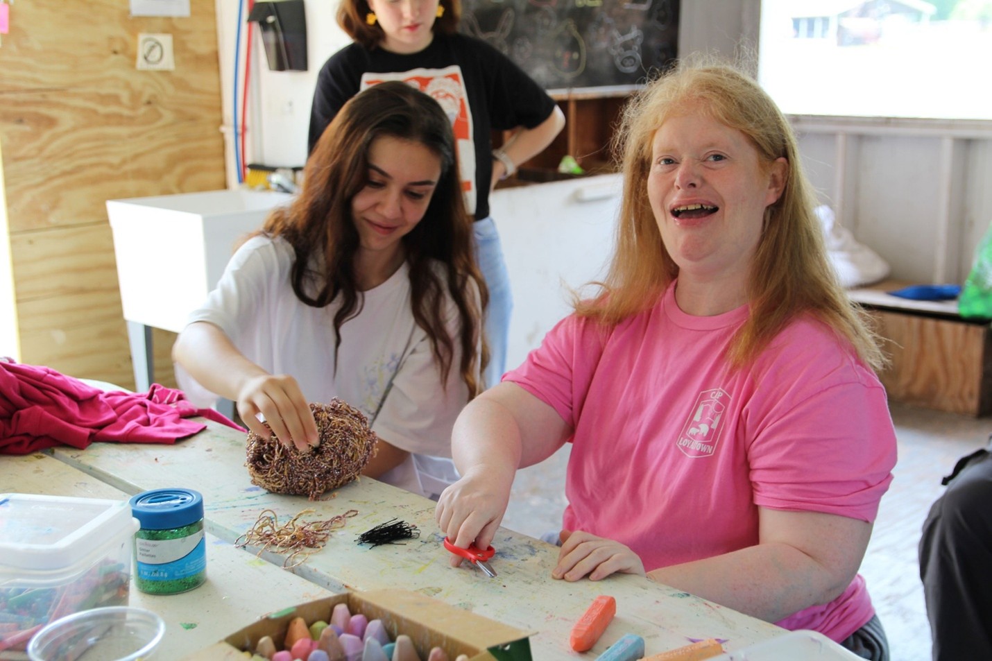 Camp Loyaltown camper Caroline Casey does crafts with a counselor